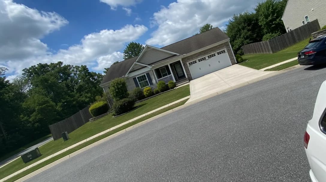 Exterior property photo taken from an awkward angle with perspective distortion and poor framing